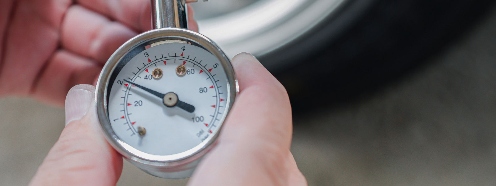 Person holding tire pressure gauge